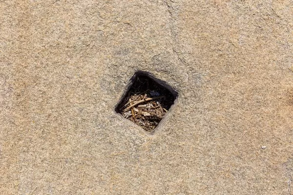 Hole for a tent pole in a stone at the Agora of the Competaliasts, market at Delos archaeological site
