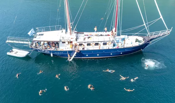 Holiday fun in Greece in summer 2021: tourists swimming in the waters of Peristera during a sailing boat trip