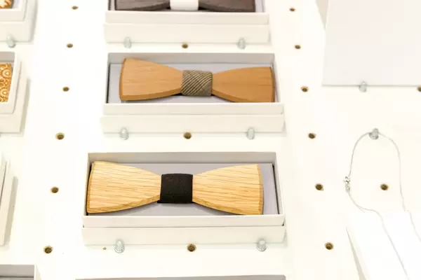 Hölzerne Fliegen für Herrenanzüge in Boxen auf weißem Verkaufsregal