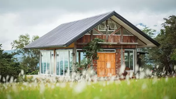 Holzhaus mit 360 Grad Blick auf grüne Umgebung durch umfassende Fensterfronten