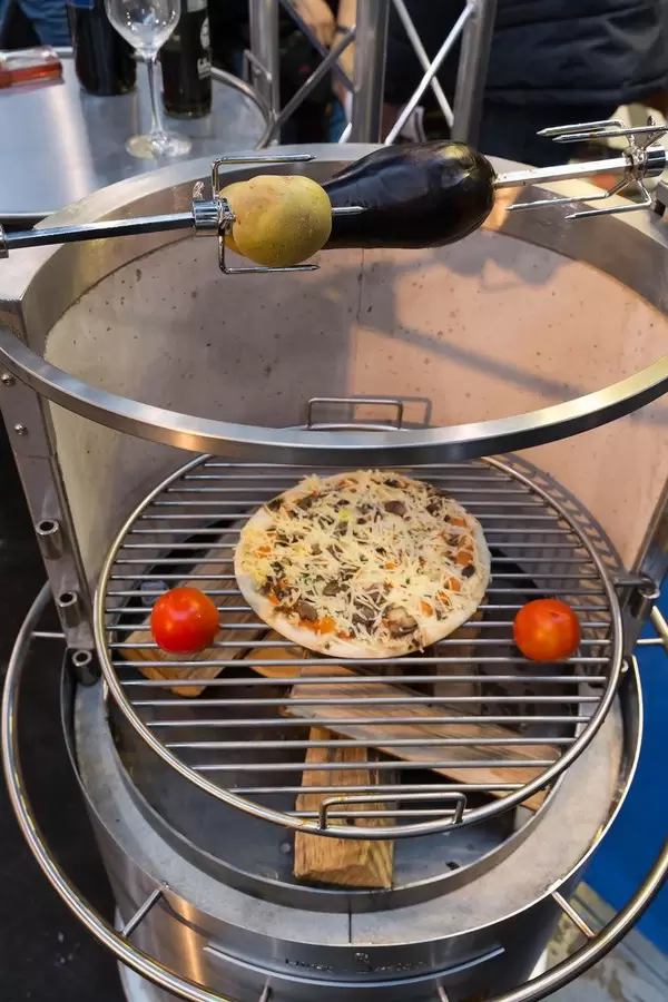 Holzkohlegrill mit Pizza und Gemüse