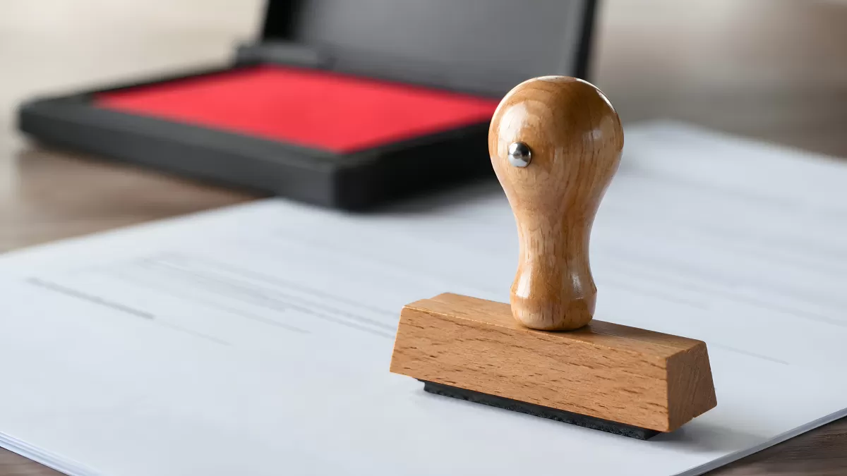 Holzstempel auf Dokumenten mit rotem Stempelkissen