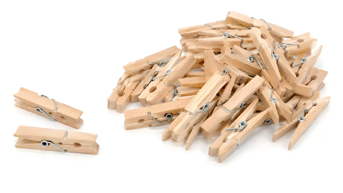 Holzwäscheklammern in großer Menge auf weißem Grund