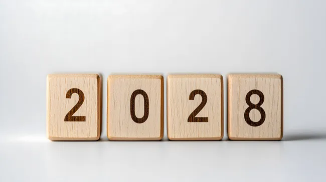 Holzwürfel mit Jahreszahl 2028 auf weißem Hintergrund
