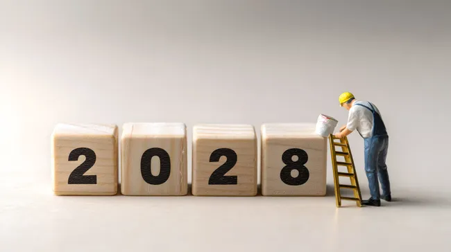 Holzwürfel mit Jahreszahl 2028 und Arbeiter bei Renovierung