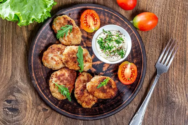 Homemade fried meat cutlets with sauce and herbs