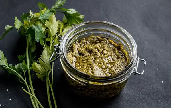 Homemade green pesto on a black table