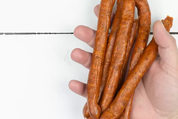 Homemade Sausages in the hand with copy space above the table
