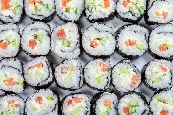 Homemade sliced Maki rolls with salmon, avocado and cucumber. Top view (Flip 2019)