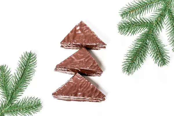 Honey chocolate cakes on a white background with Christmas tree branches (Flip 2019)