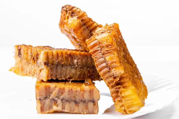 Honeycomb slices filled with honey in white background