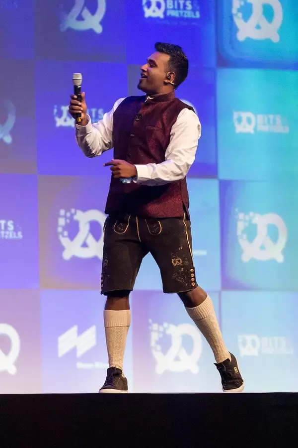 Host and speaker Dan Ram has fun on stage in his Oktoberfest outfit with lederhosen