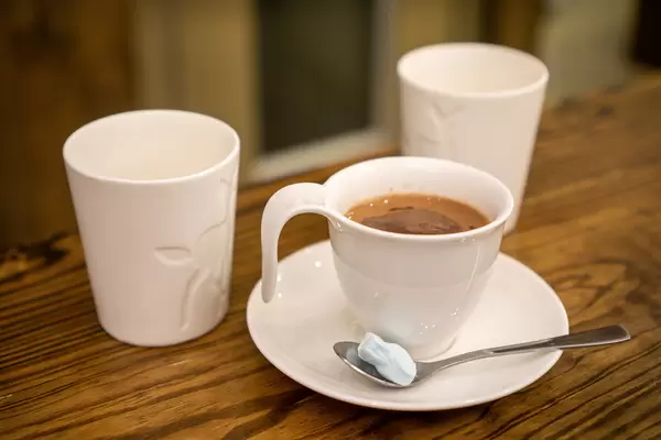Hot Chocolate in a White Mug with Marshmallow on a Spoon