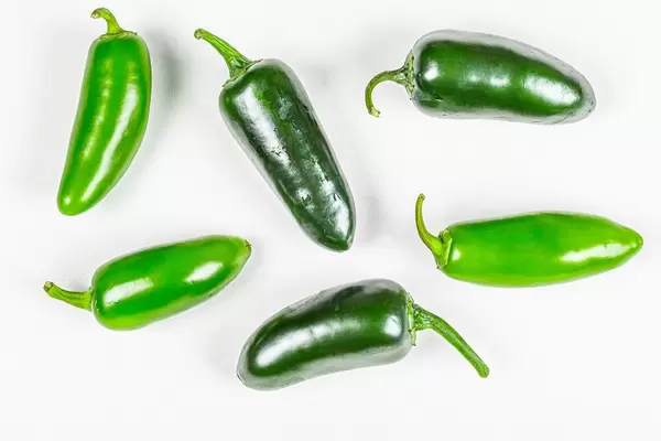 Hot green chili jalapeno on a white background, top view