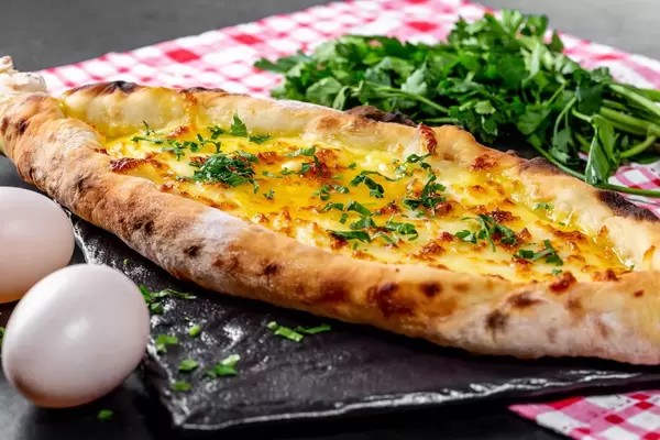 Hot open khachapuri with chicken egg and greens