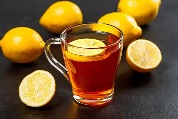 Hot tea with fresh yellow lemons on black background (Flip 2019)