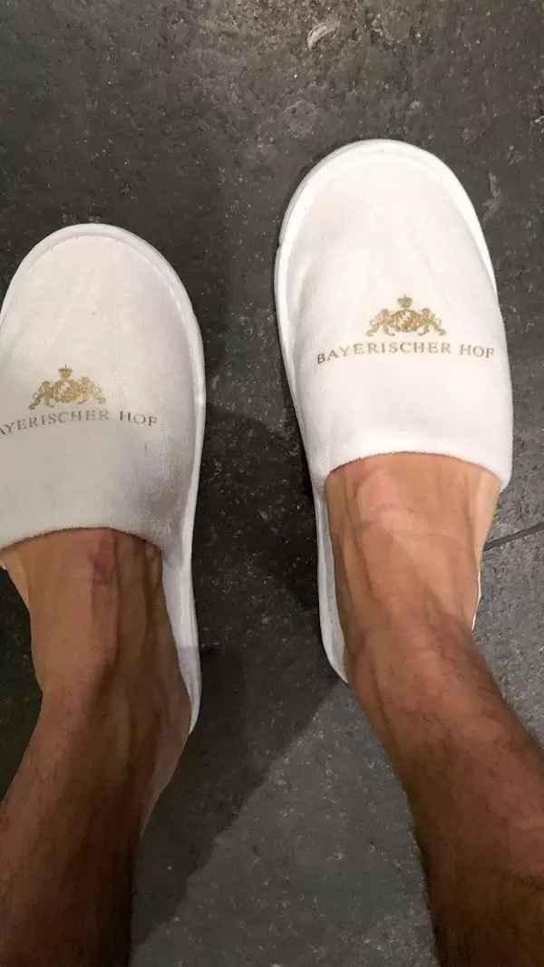 Hotelgast trägt weiße Hausschlappen vom Luxushotel Bayerischer Hof in München