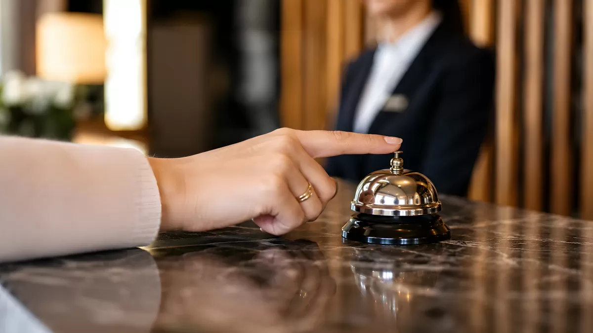 Hotelrezeption mit Serviceklingel und Empfangsmitarbeiter