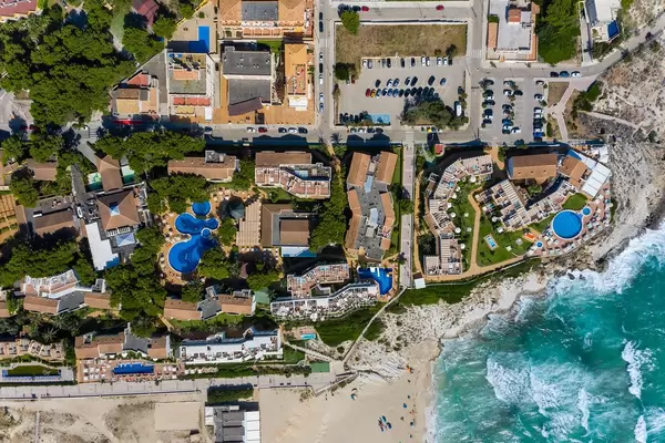Hotels and apartment complexes with pools for holidays in Majorca. Overhead shot, Cala Mesquida
