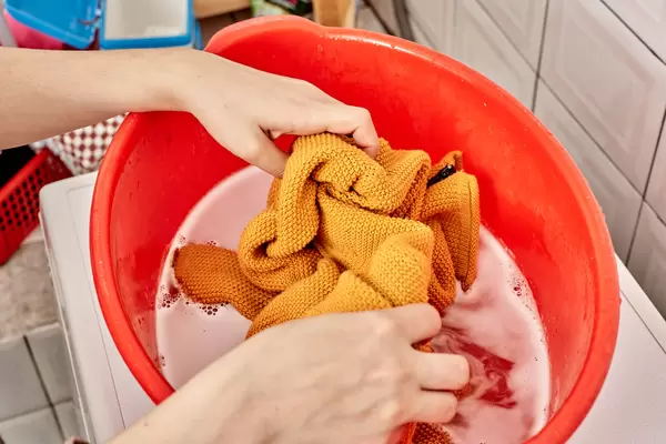 House maid washing colored clothes by hand