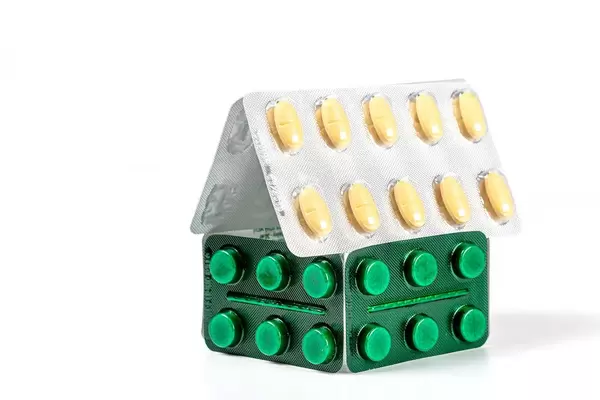 House of pills in blisters on a white background