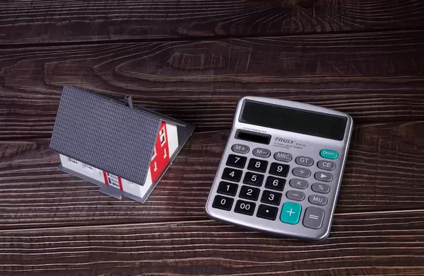 House with calculator on wooden table