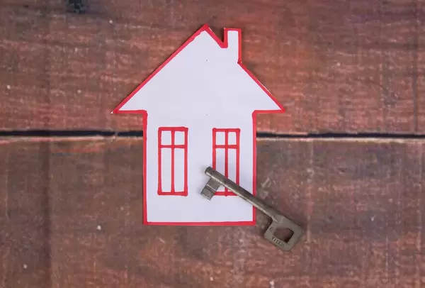 House with key on wooden background