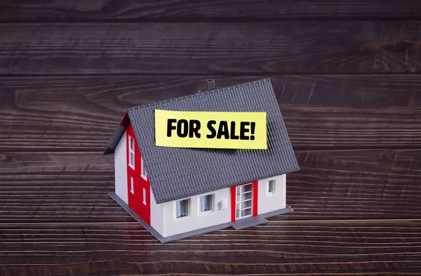 House with yellow For Sale sticker