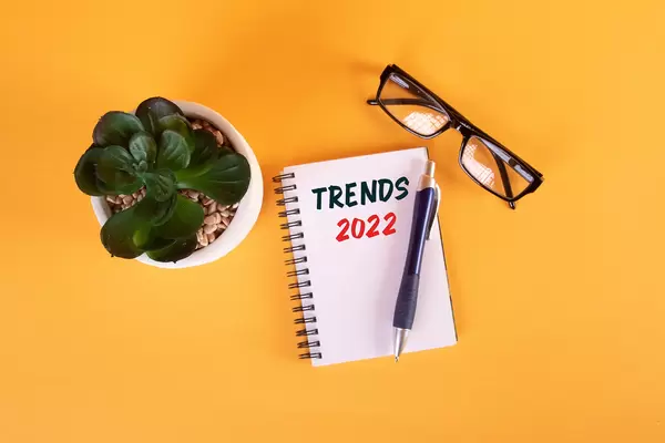 Houseplant and notebook with Trends 2022 text on yellow background