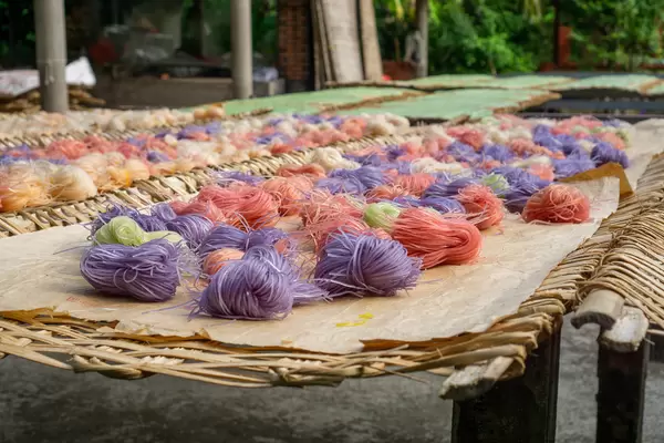 Hu Tieu Tapioka Nudeln mit verschiedenen Zutaten wie Süßkartoffeln oder blauer Schamblume trocknen in der Sonne in einer lokalen Nudelfabrik in Can Tho, Vietnam
