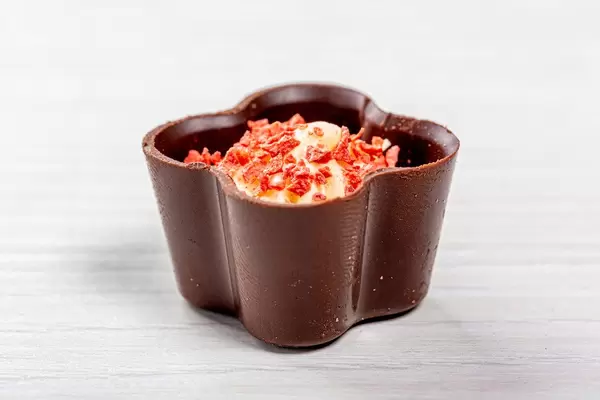 Hübsche Schokoladenpraline mit weißer Creme und Erdbeerstücken