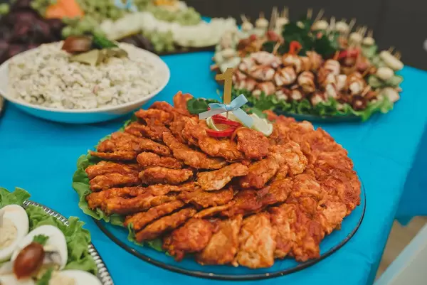 Hühnerfleischteller mit Tomatensauce auf einem bedeckten Tisch