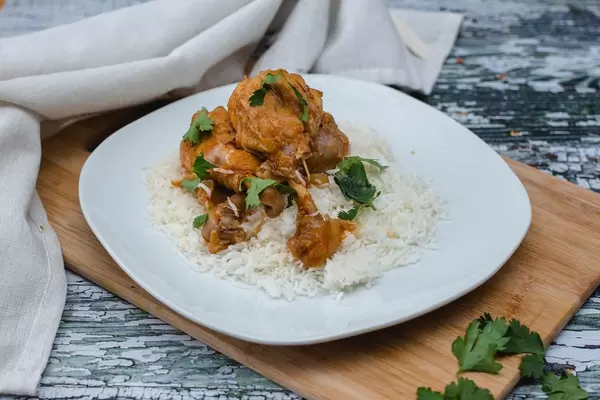 Hühnertrommelstöcke mit Reis auf weißem Teller