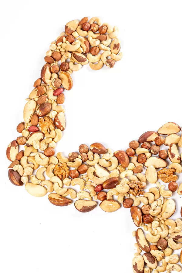 Human hand and body part made from assorted nuts, healthy food concept