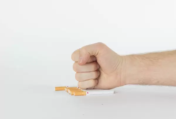 Human hand breaking cigarettes
