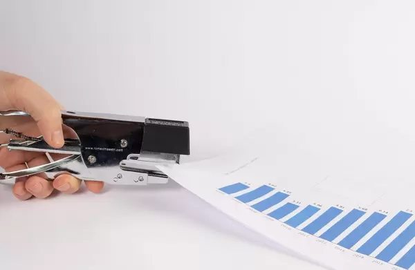 Human hand is stapling the paper with stapler