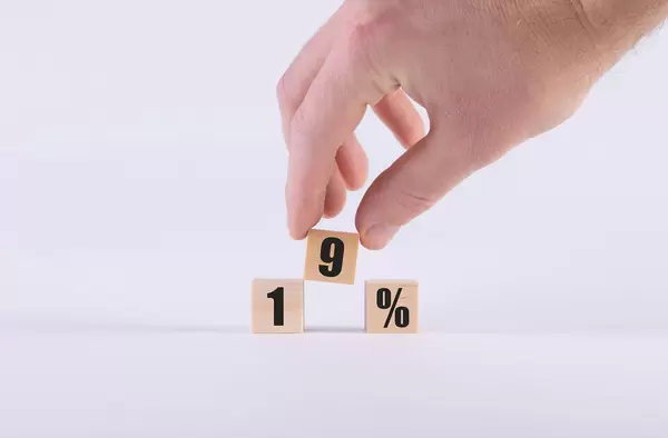 Human hand with 19% text on wooden cubes
