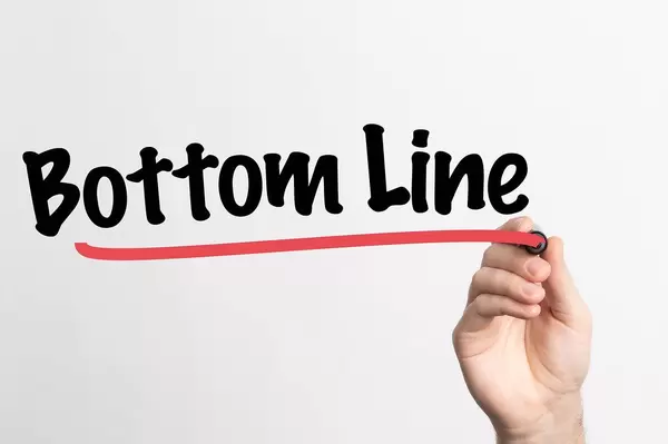 Human hand writing Bottom Line on whiteboard