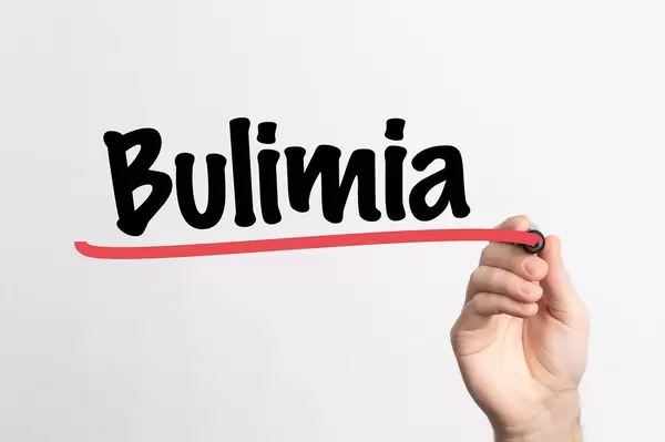 Human hand writing Bulimia on whiteboard