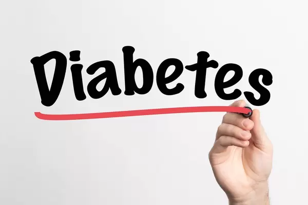 Human hand writing Diabetes on whiteboard