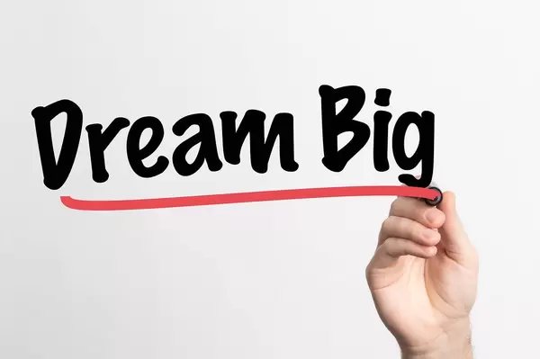 Human hand writing Dream Big on whiteboard