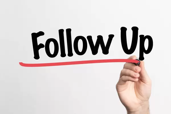 Human hand writing Follow Up on whiteboard