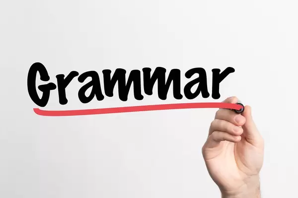 Human hand writing Grammar on whiteboard