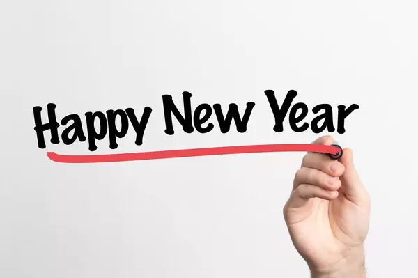 Human hand writing Happy New Year on whiteboard