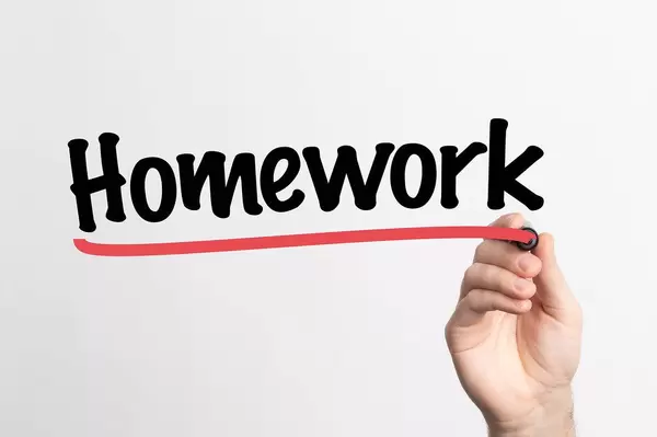 Human hand writing Homework on whiteboard