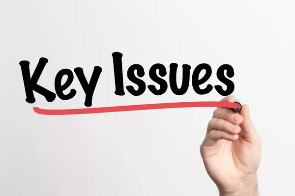 Human hand writing Key Issues on whiteboard