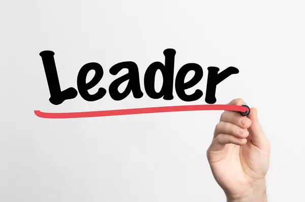 Human hand writing Leader on whiteboard