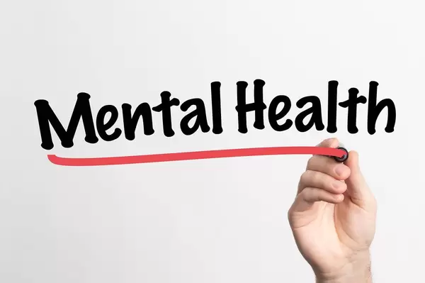 Human hand writing Mental Health on whiteboard