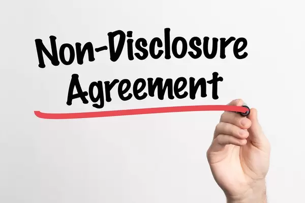 Human hand writing Non-Disclosure Agreement on whiteboard