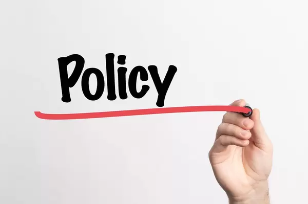 Human hand writing Policy on whiteboard